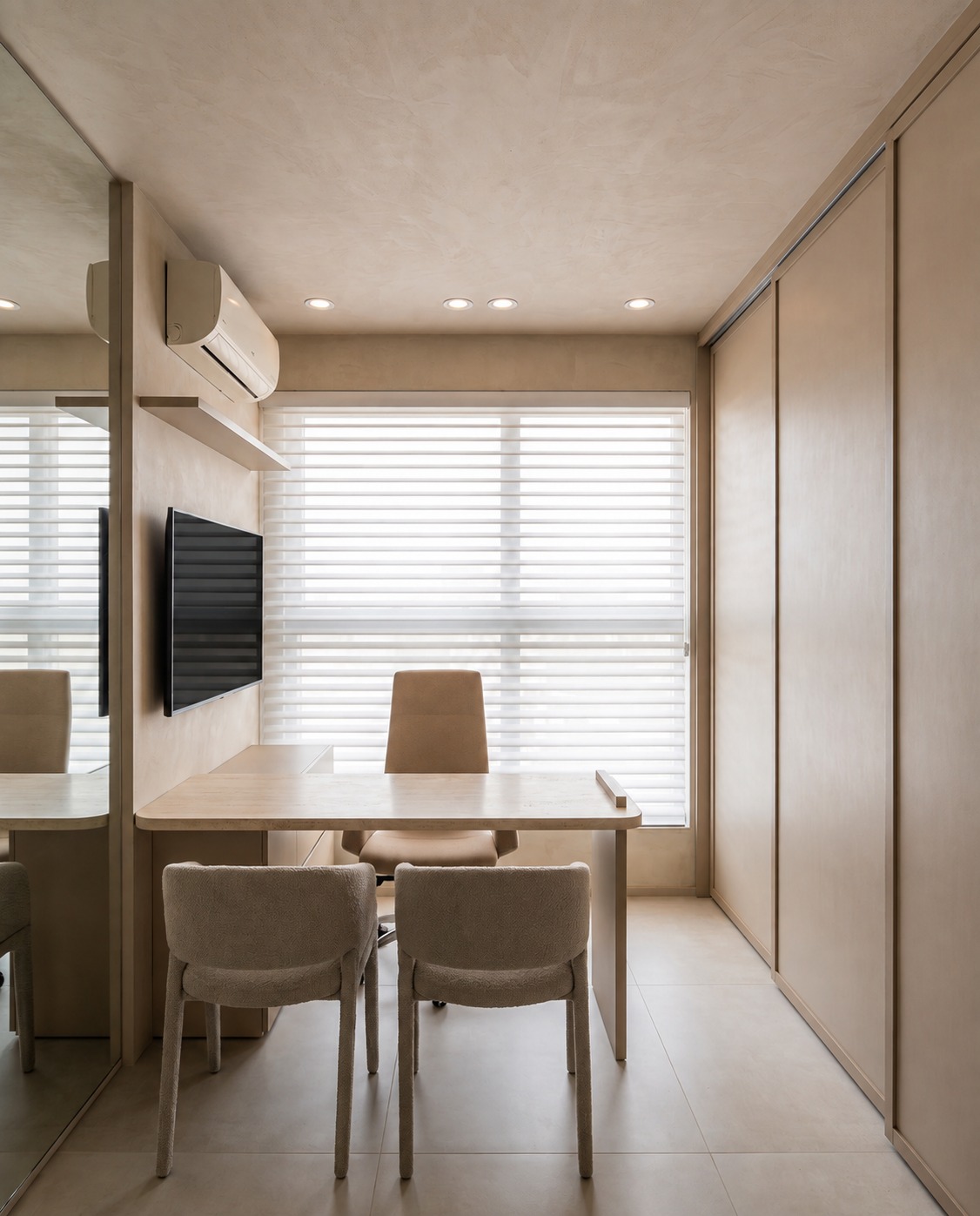 Sala de consulta com mesa em carvalho, cadeiras em bouclé e painel espelhado
